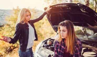 Young girls experiencing problems with broken down car