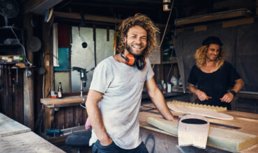 two happy young men working on skateboards in their workshop