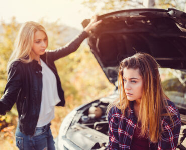 Young girls experiencing problems with broken down car