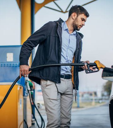 man putting petrol into a car