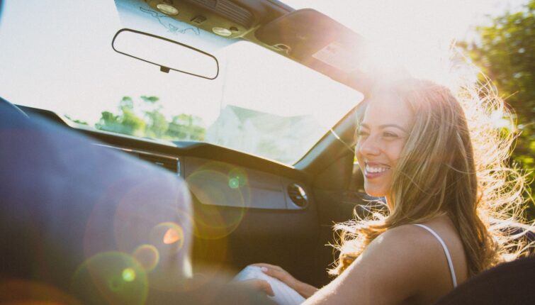 young happy woman in a car subscription vehicle