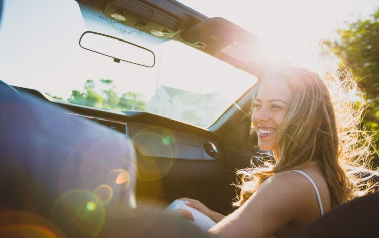 young happy woman in a car subscription vehicle