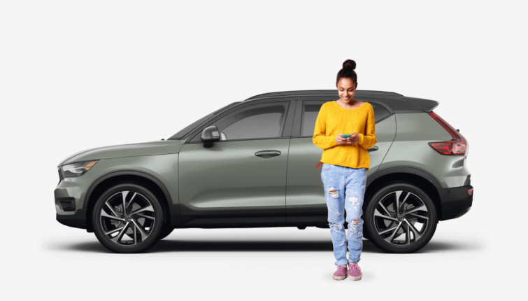 side view of olive SUV car with woman next to the vehicle