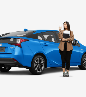 woman standing in front of blue hybrid toyota prius