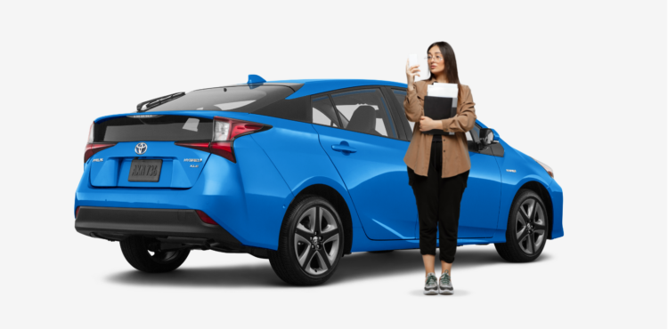 woman standing in front of blue hybrid toyota prius