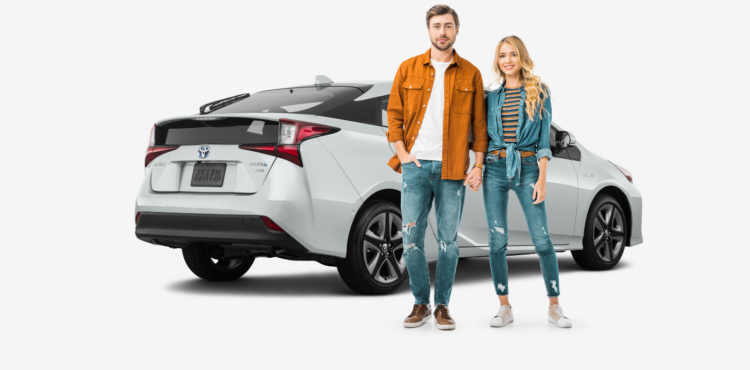 young couple standing in front of white toyota prius