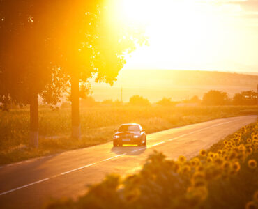 BMW M3 car drives through a beautiful scenery at sunset
