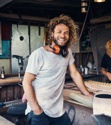 two happy young men working on skateboards in their workshop