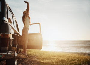 young woman enjoying a road trip along the coast