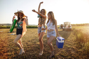 Joyful girls running through crop fields towards a beach