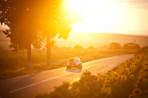 BMW M3 car drives through a beautiful scenery at sunset