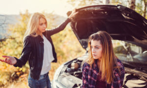 Young girls experiencing problems with broken down car