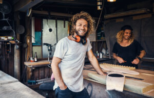 two happy young men working on skateboards in their workshop