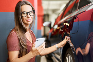 young woman with scratched car at underground parking lot