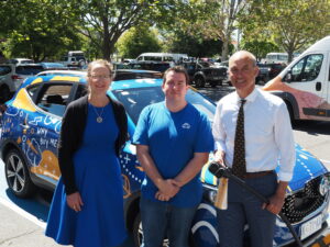 carbar employees standing in front of vehicle for aurora energy launch