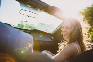 young happy woman in a car subscription vehicle