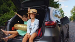 little sisters sitting in trunk waiting for charging car before travelling