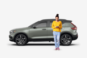 side view of olive SUV car with woman next to the vehicle