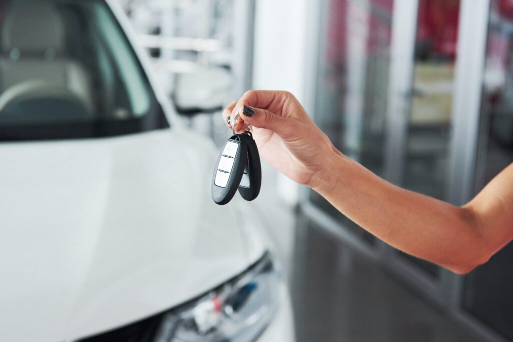 woman handing keys over to sell a car