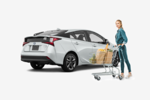 woman standing in front of white Toyota Prius after grocery shopping
