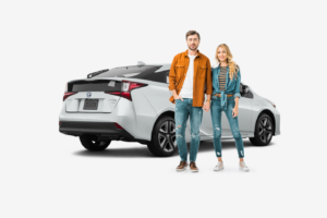 young couple standing in front of white toyota prius