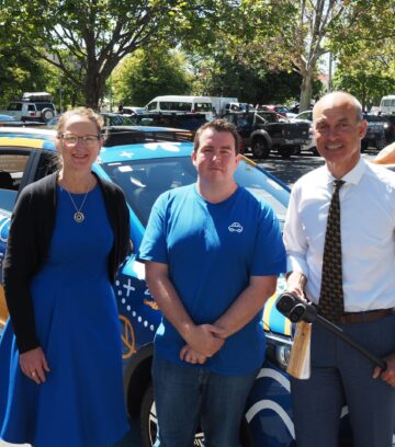 carbar employees standing in front of vehicle for aurora energy launch