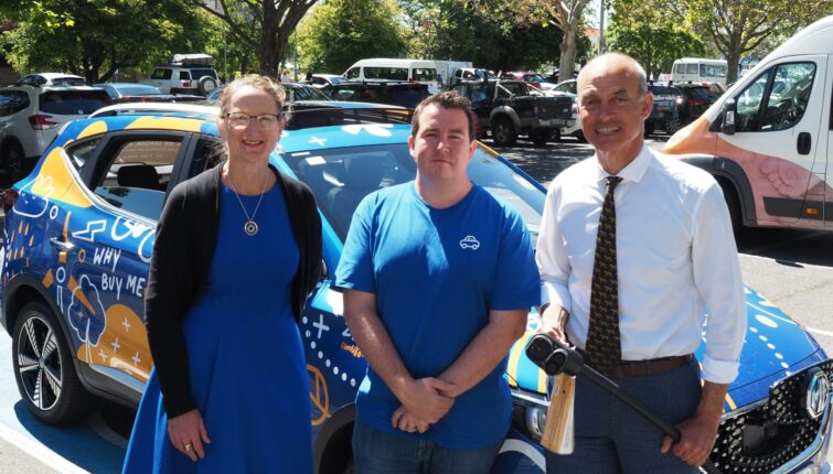 carbar employees standing in front of vehicle for aurora energy launch