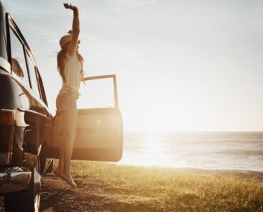 young woman enjoying a road trip along the coast