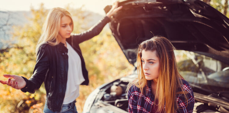 Young girls experiencing problems with broken down car