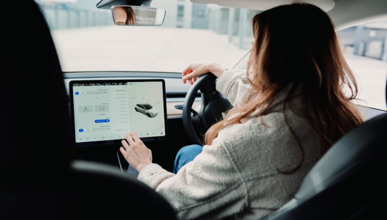 woman inside EV using ipad vehicle app