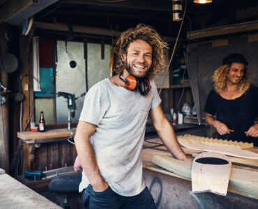 two happy young men working on skateboards in their workshop