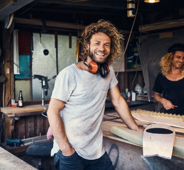 two happy young men working on skateboards in their workshop