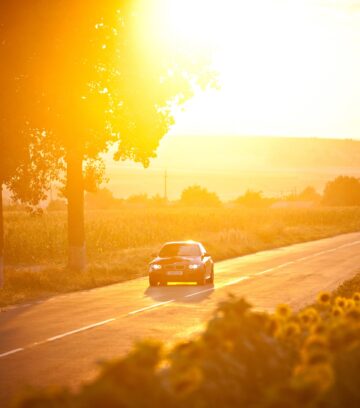 BMW M3 car drives through a beautiful scenery at sunset