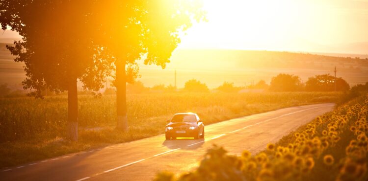 BMW M3 car drives through a beautiful scenery at sunset