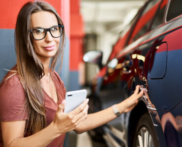 young woman with scratched car at underground parking lot