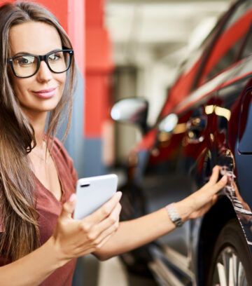 young woman with scratched car at underground parking lot