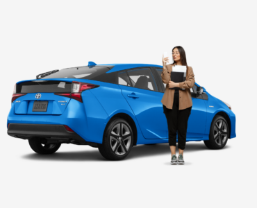 woman standing in front of blue hybrid toyota prius