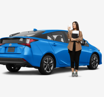 woman standing in front of blue hybrid toyota prius