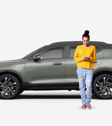 side view of olive SUV car with woman next to the vehicle