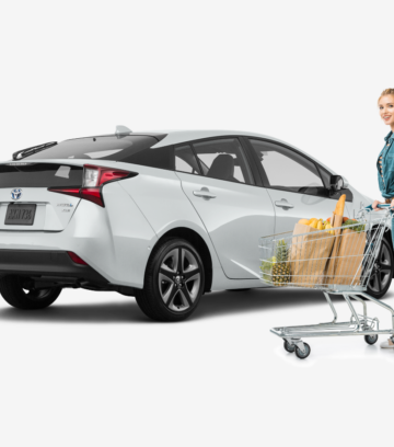 woman standing in front of white Toyota Prius after grocery shopping