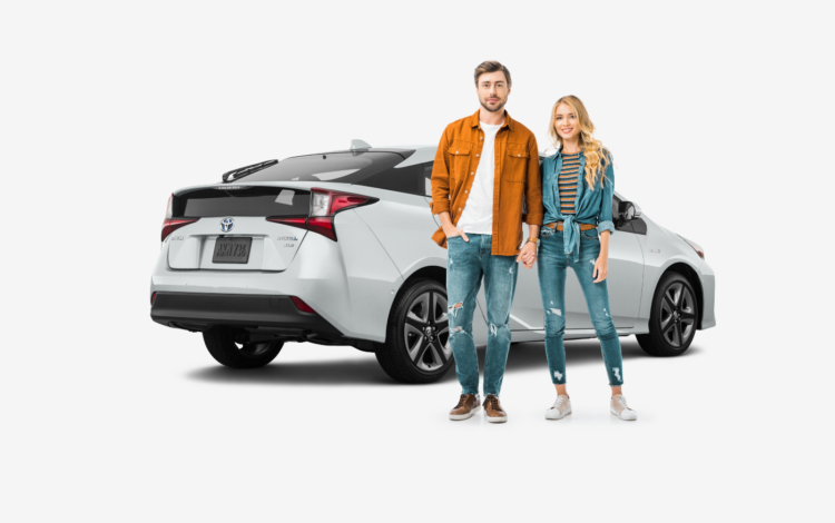 young couple standing in front of white toyota prius