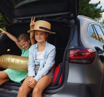 little sisters sitting in trunk waiting for charging car before travelling