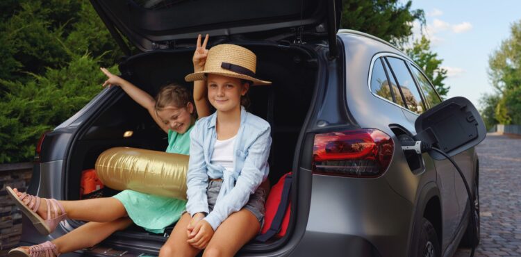 little sisters sitting in trunk waiting for charging car before travelling