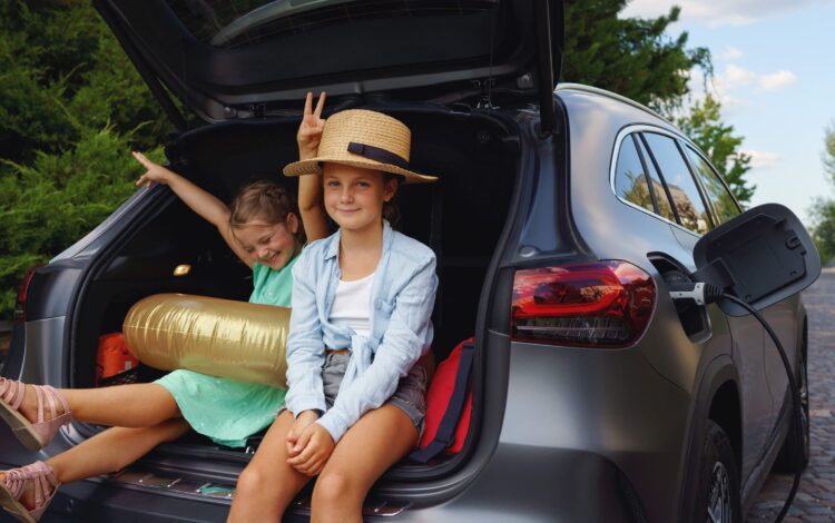 little sisters sitting in trunk waiting for charging car before travelling